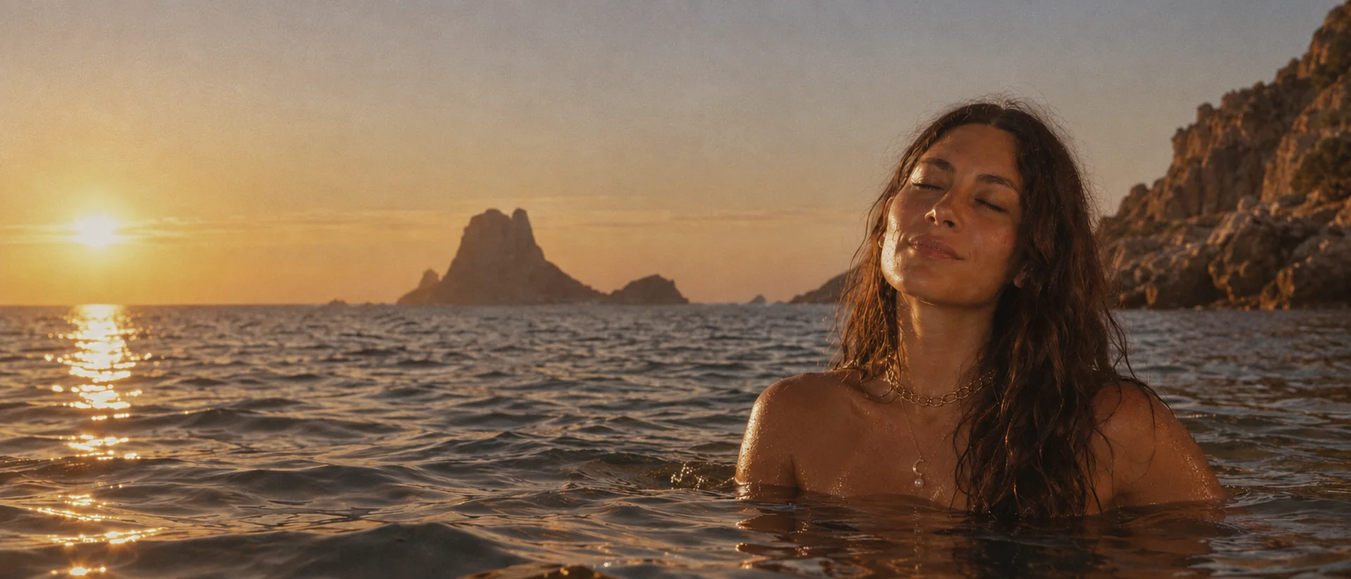 Mujer en el mar al atardecer, con los ojos cerrados